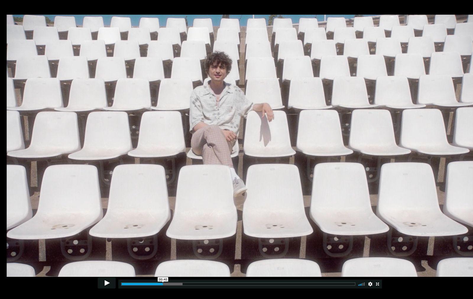 a man sitting in a row of white chairs