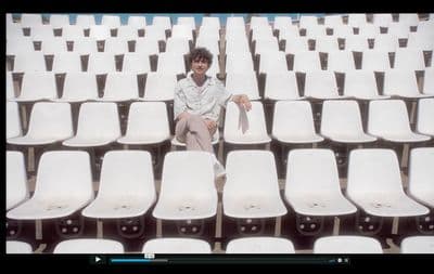 a man sitting in a row of white chairs