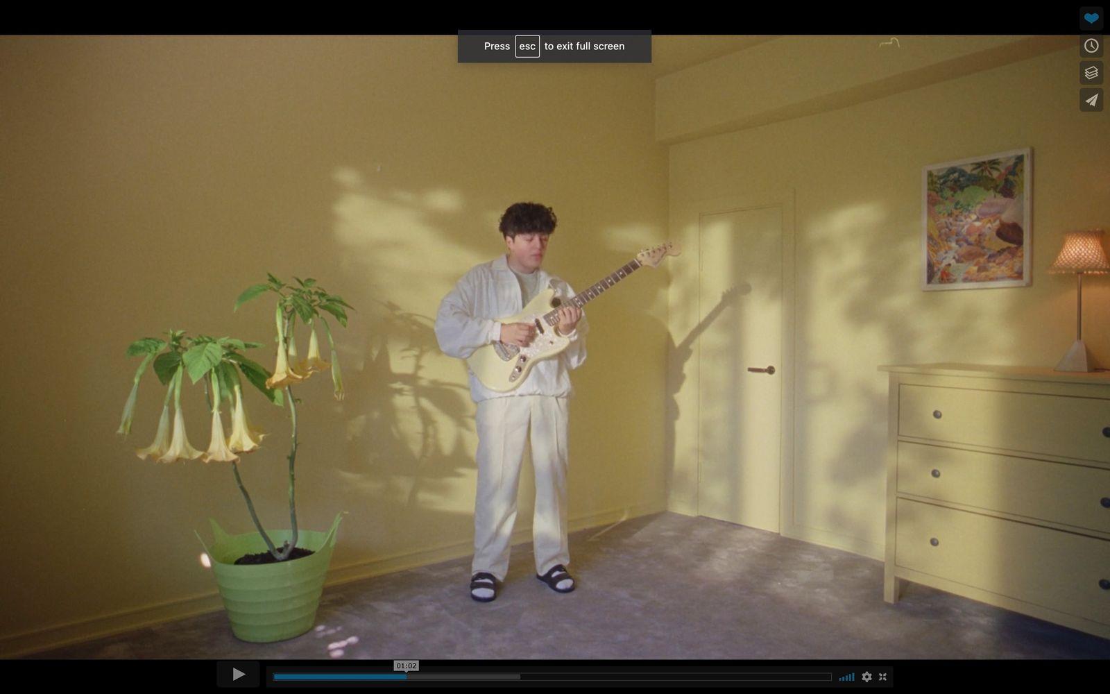 a man standing in a room playing a guitar