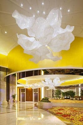 a large chandelier hanging from the ceiling of a hotel lobby