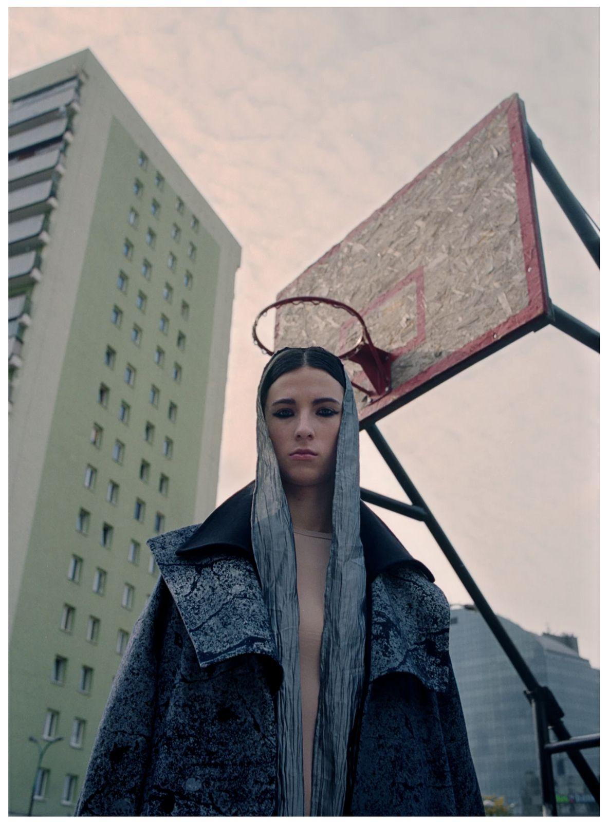 a woman standing in front of a basketball hoop