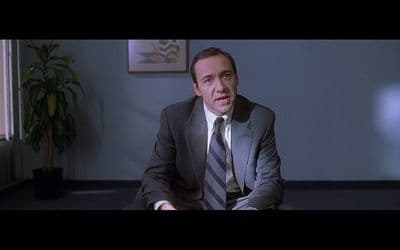 a man in a suit and tie sitting down