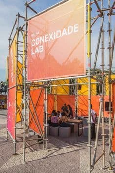 a group of people sitting at a table under scaffolding