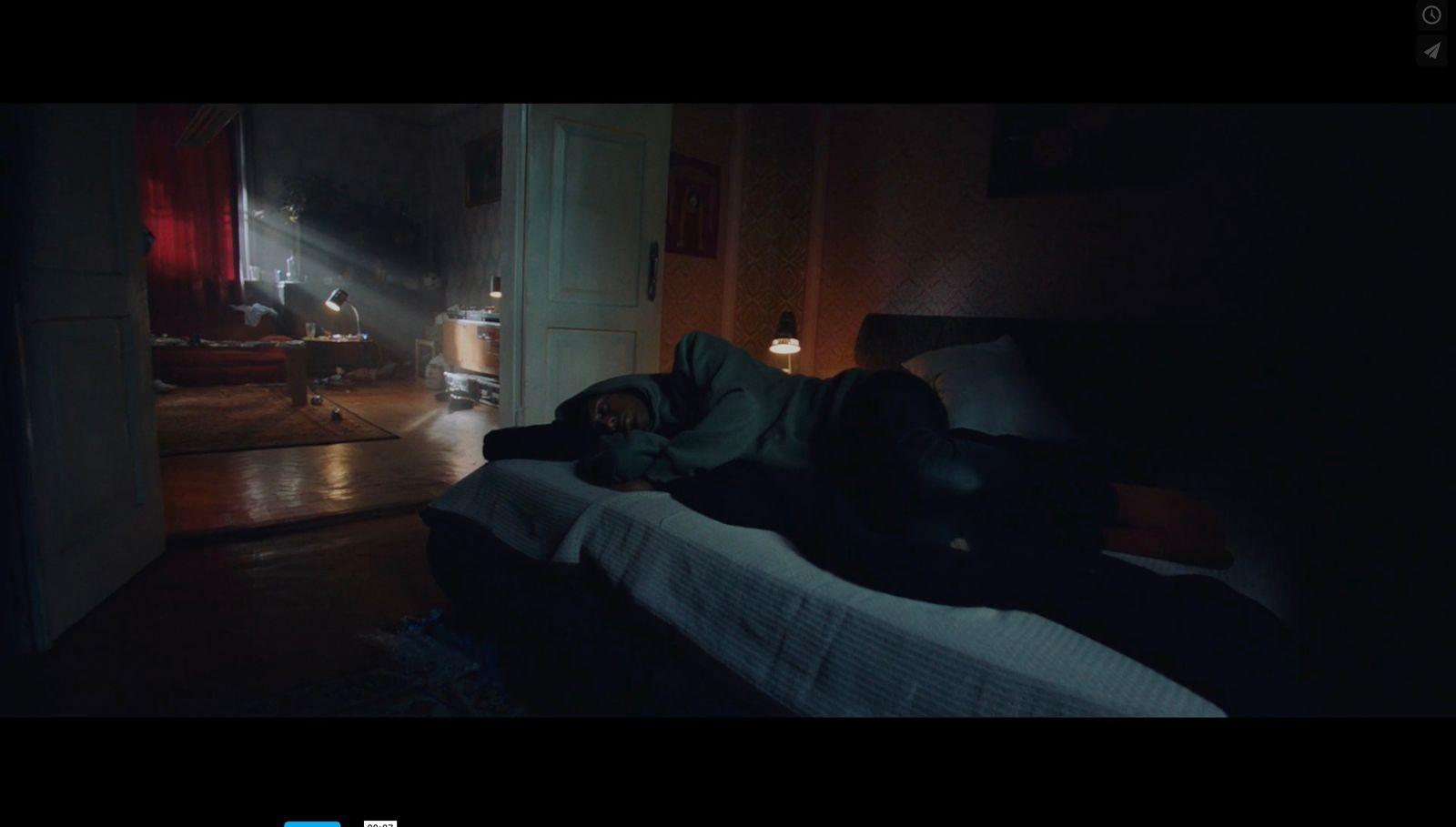 a person laying on a bed in a dark room
