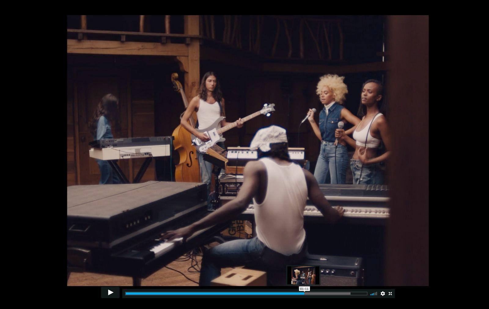 a group of people standing around a piano