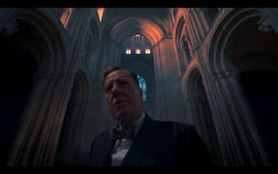 a man in a tuxedo standing in front of a cathedral