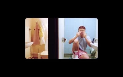 a man sitting on a toilet in a bathroom