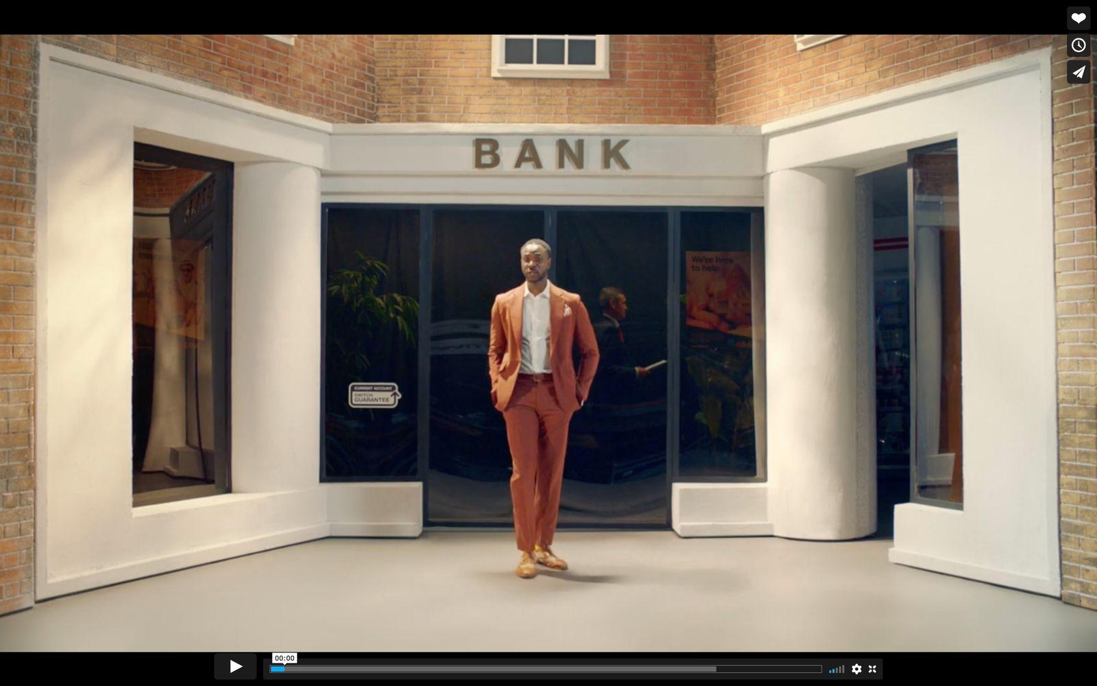 a man in an orange suit is standing in front of a bank