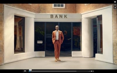 a man in an orange suit is standing in front of a bank