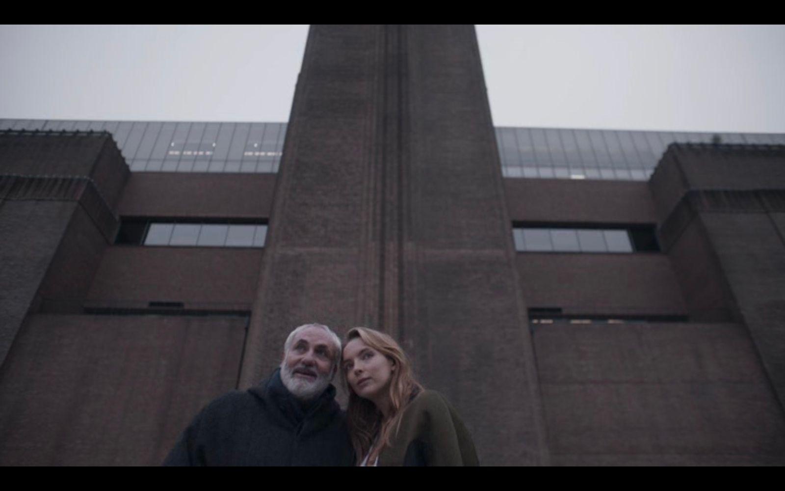 a man and a woman standing in front of a tall building
