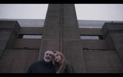 a man and a woman standing in front of a tall building