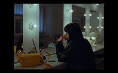 a woman in a hijab is looking at her reflection in a mirror