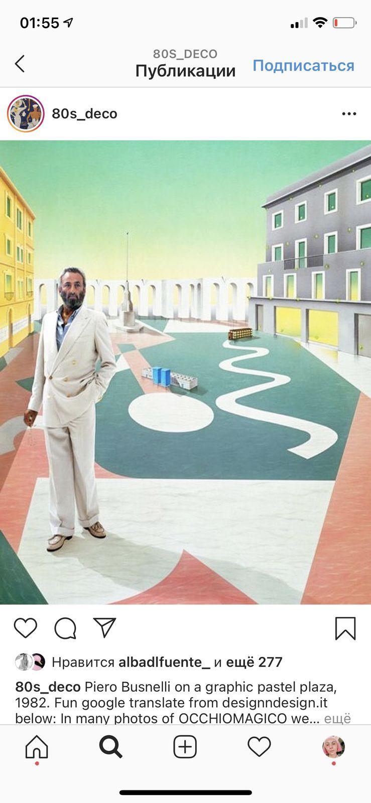 a man in a white suit standing in front of a painting