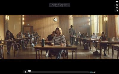 a group of people sitting at desks in a room