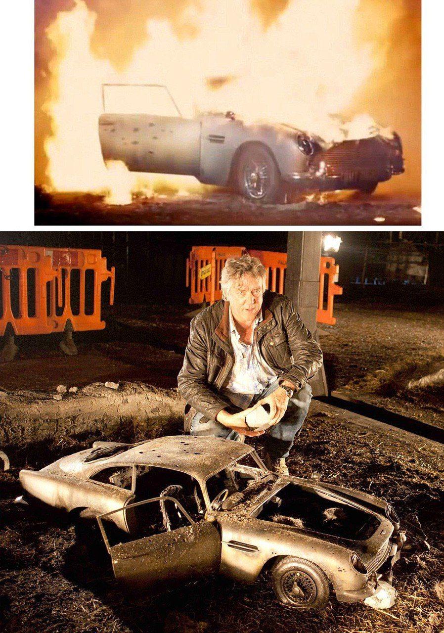 a man standing next to a car on top of a pile of dirt