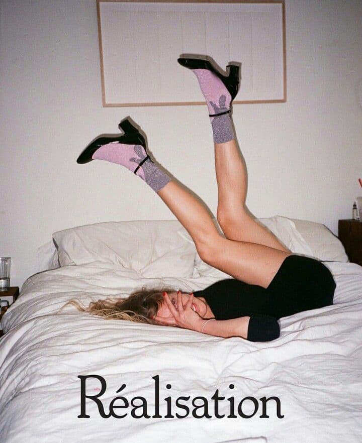 a woman laying on a bed with her legs up