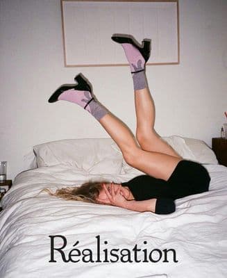 a woman laying on a bed with her legs up