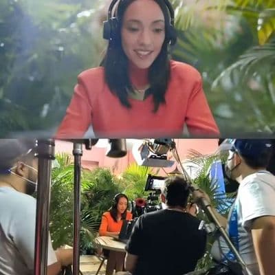 a woman with headphones on in front of a camera