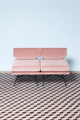 a pink couch sitting on top of a checkered floor