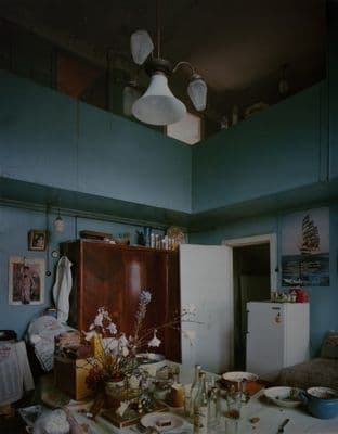 a kitchen with a refrigerator and a table with food on it
