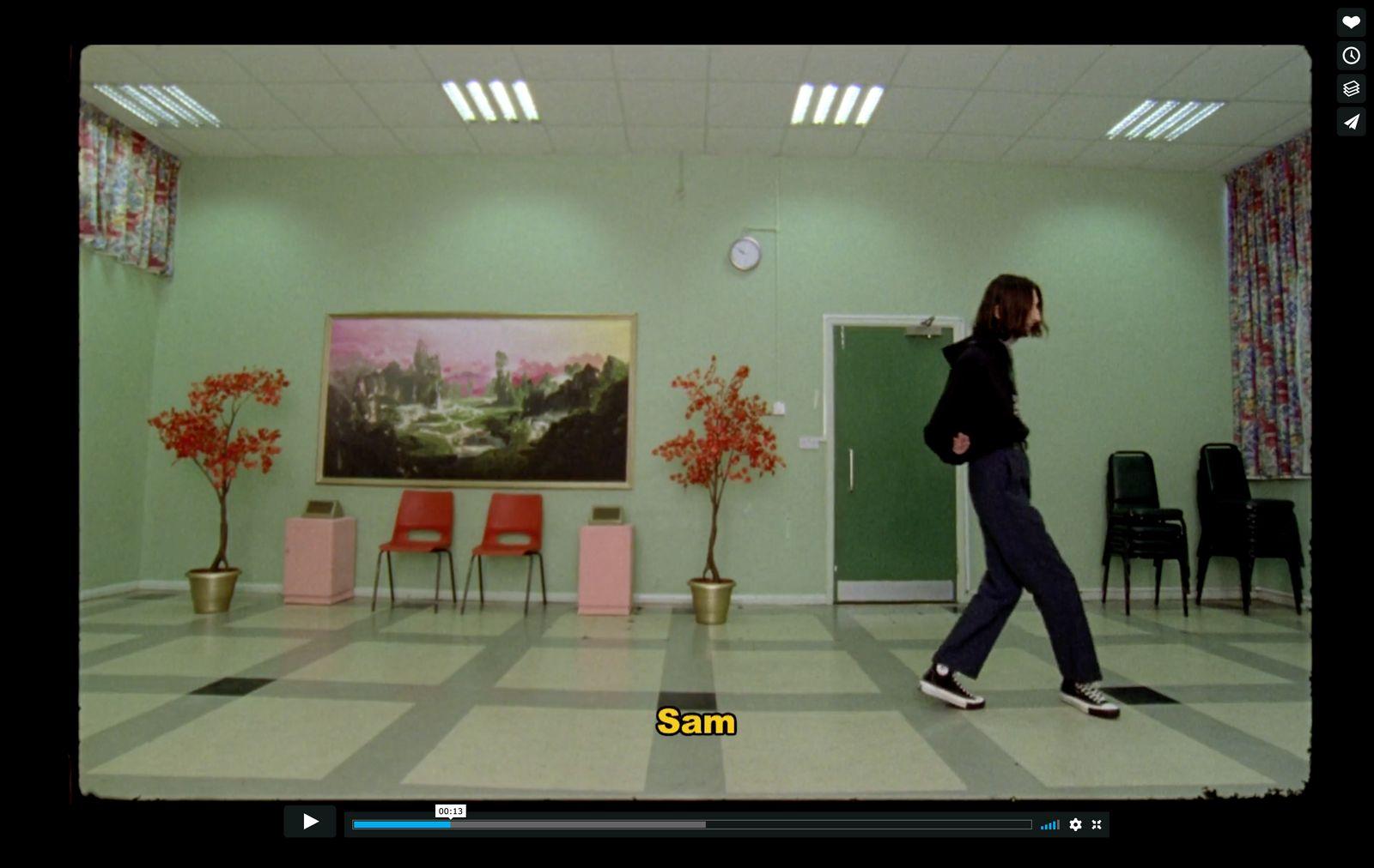 a woman walking through a room with a painting on the wall