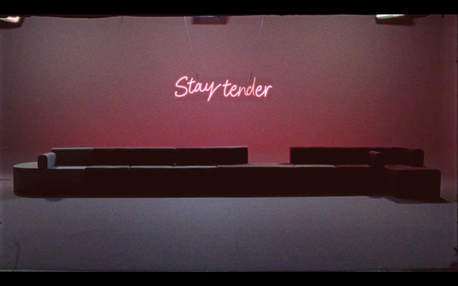 a room with a couch and a neon sign on the wall