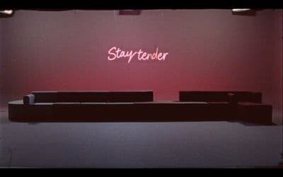 a room with a couch and a neon sign on the wall