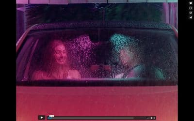 a man and a woman sitting in a car in the rain