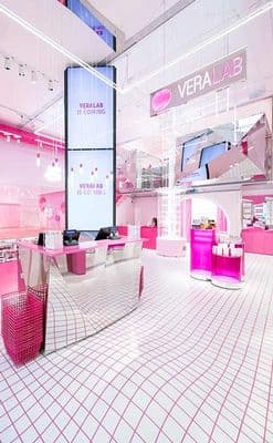 a pink and white store with a big screen