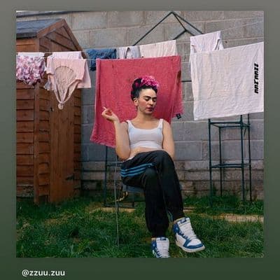 a woman sitting on a chair in front of a clothes line