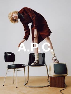a woman standing on top of a chair next to a tv