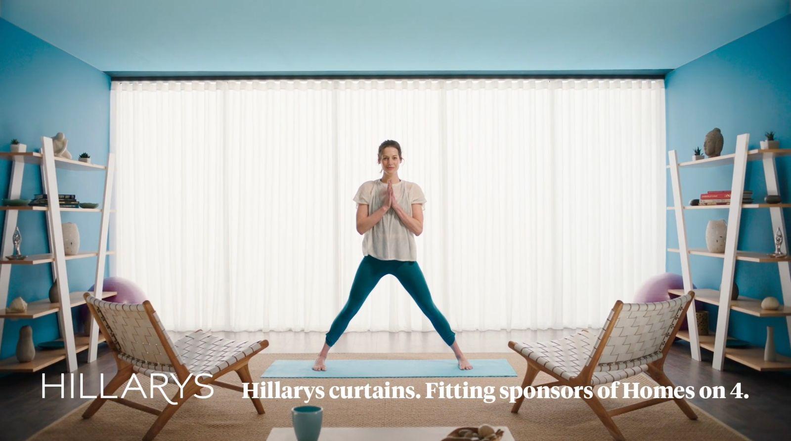 a woman standing on a yoga mat in a living room