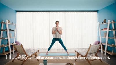 a woman standing on a yoga mat in a living room