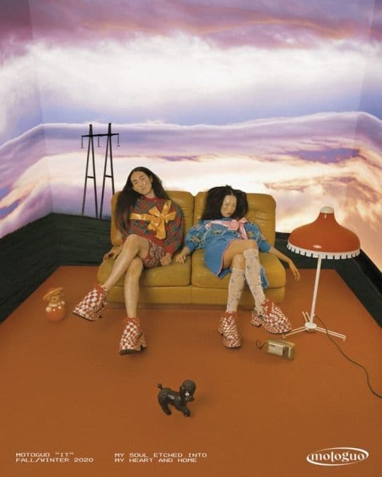 two girls sitting on a couch in a room