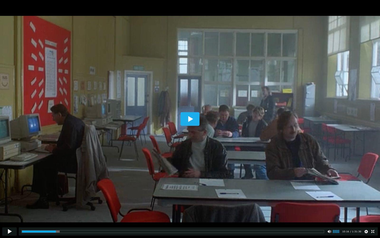 a group of people sitting at desks in a room