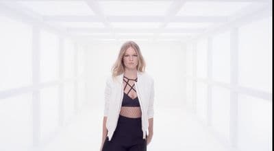 a woman standing in a room with a white background