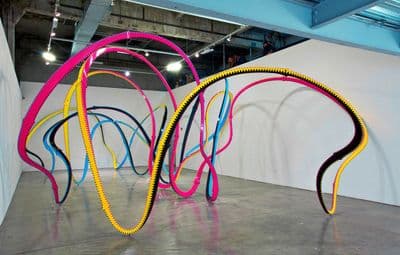 a group of colorful hoses sitting on top of a cement floor