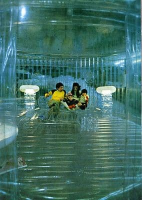 a group of people sitting in a room filled with plastic
