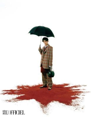 a man in a suit holding an umbrella