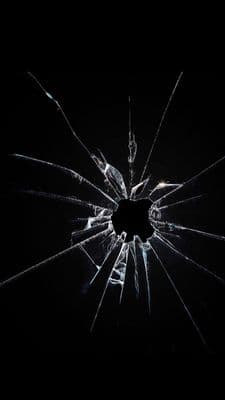 a broken glass window in the dark