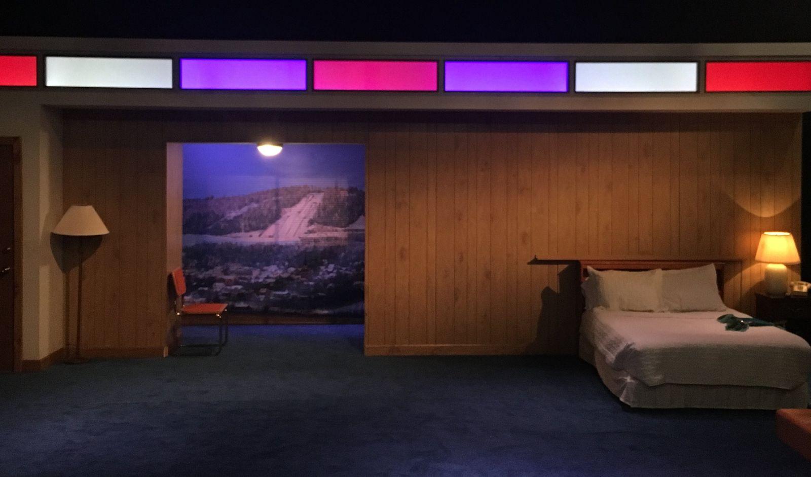 a room with a bed and a painting on the wall