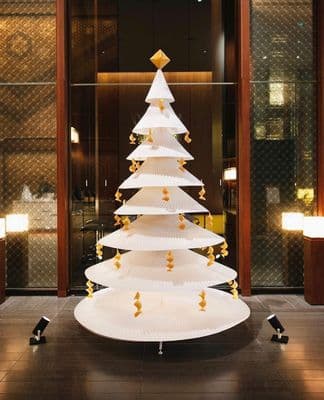 a large white christmas tree sitting inside of a building