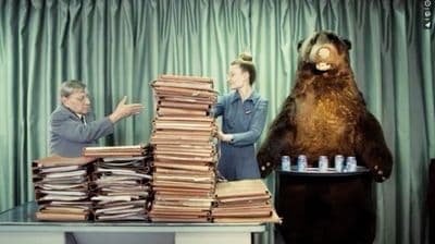 a giant bear standing next to a pile of papers