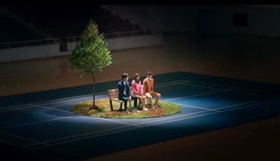 a group of people sitting on a bench next to a tree