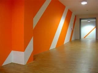an orange and white striped wall in a hallway
