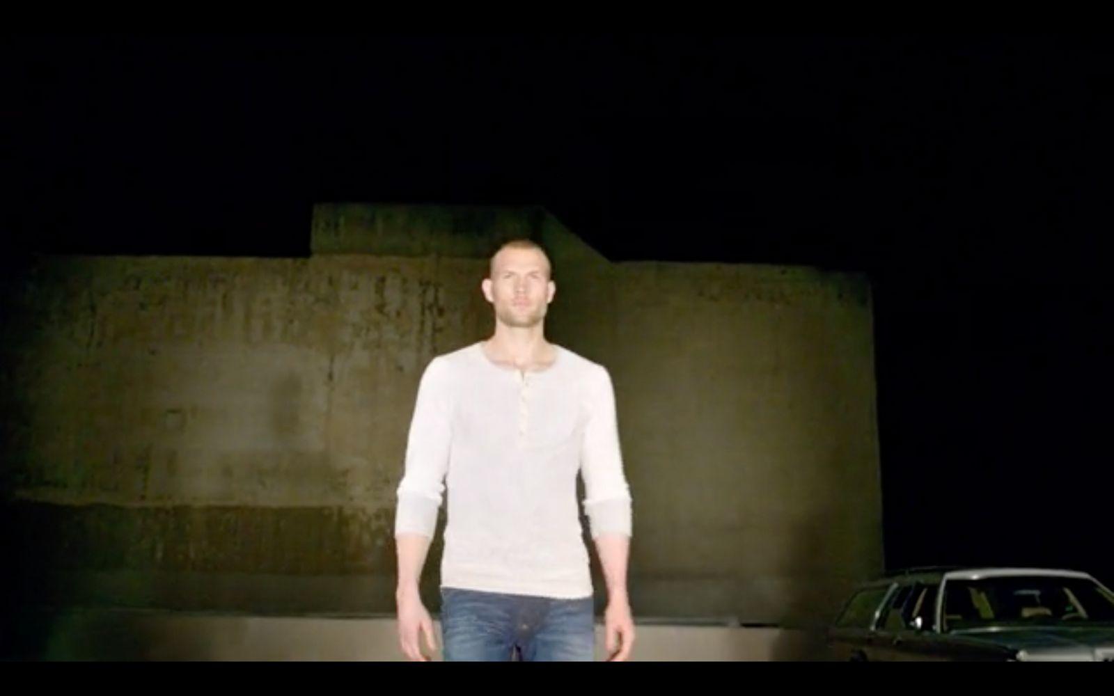 a man standing in front of a car in the dark