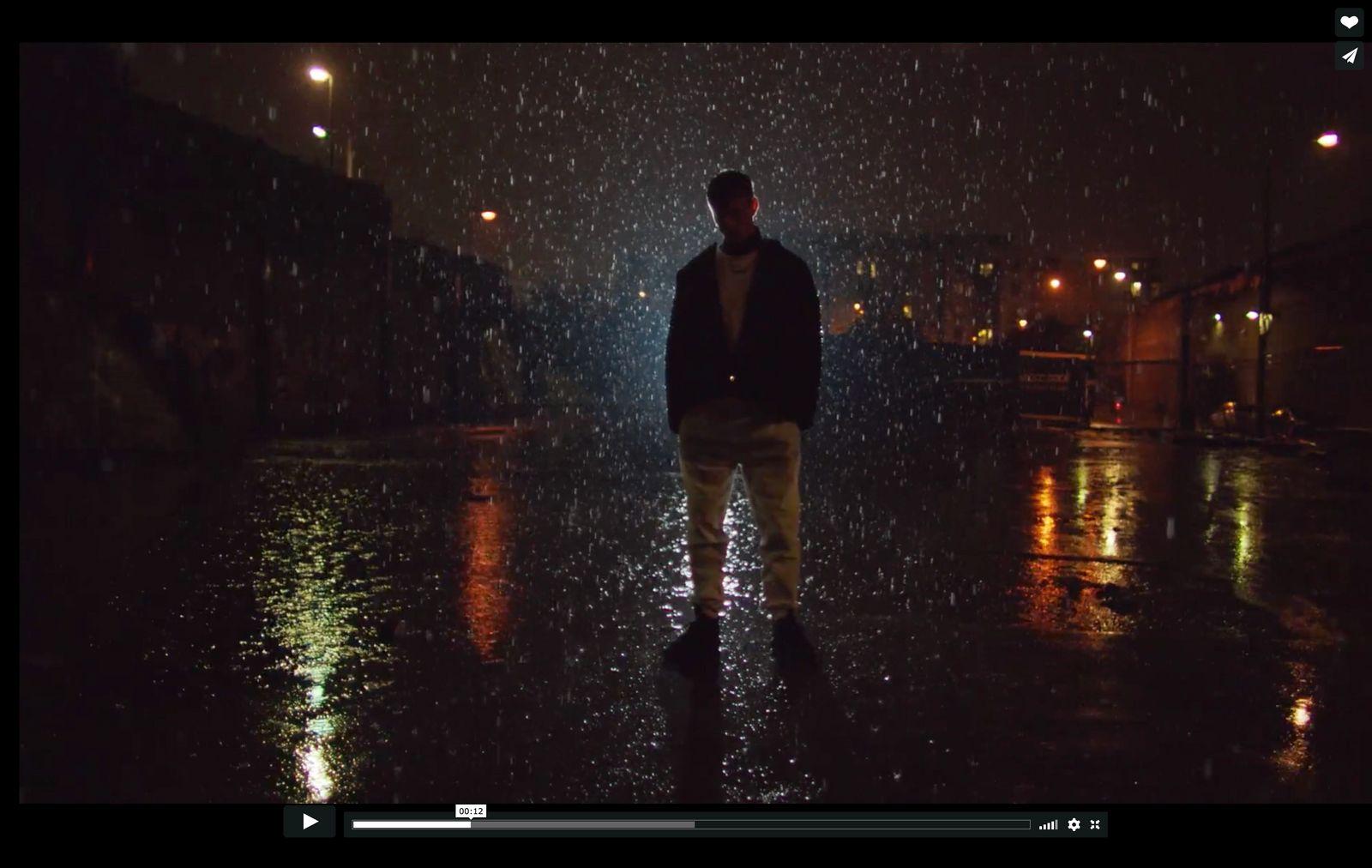 a man walking in the rain at night