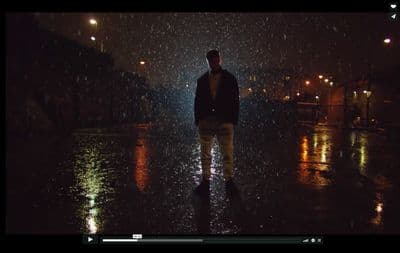 a man walking in the rain at night