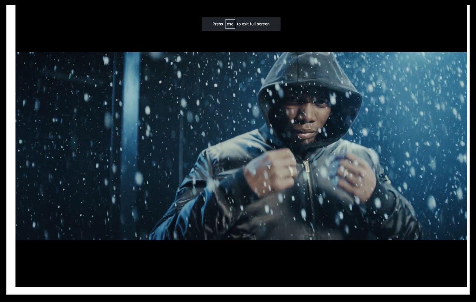 a man in a hooded jacket standing in the snow