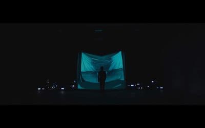 a person standing in front of a large screen in the dark